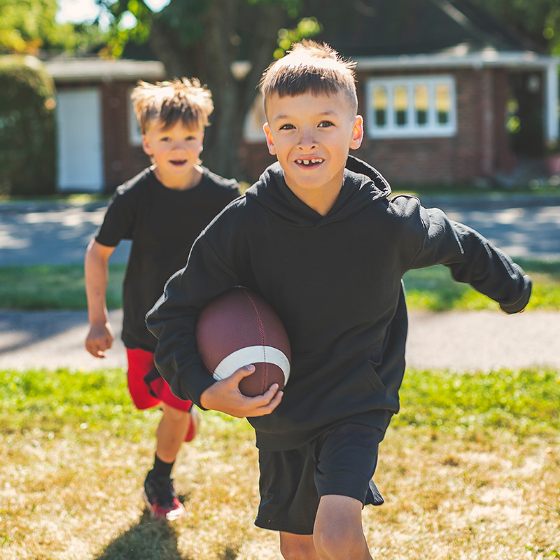 Kids playing football on a fall day.