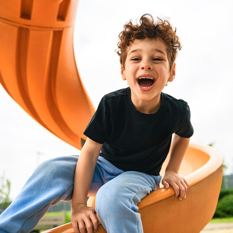 A young boy on a slide.